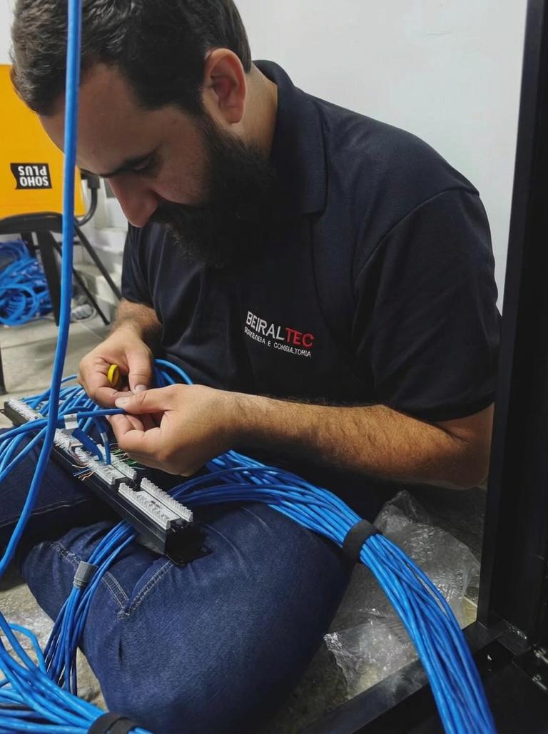 Técnico da Beiraltec realizando cabeamento de rede em patch panel